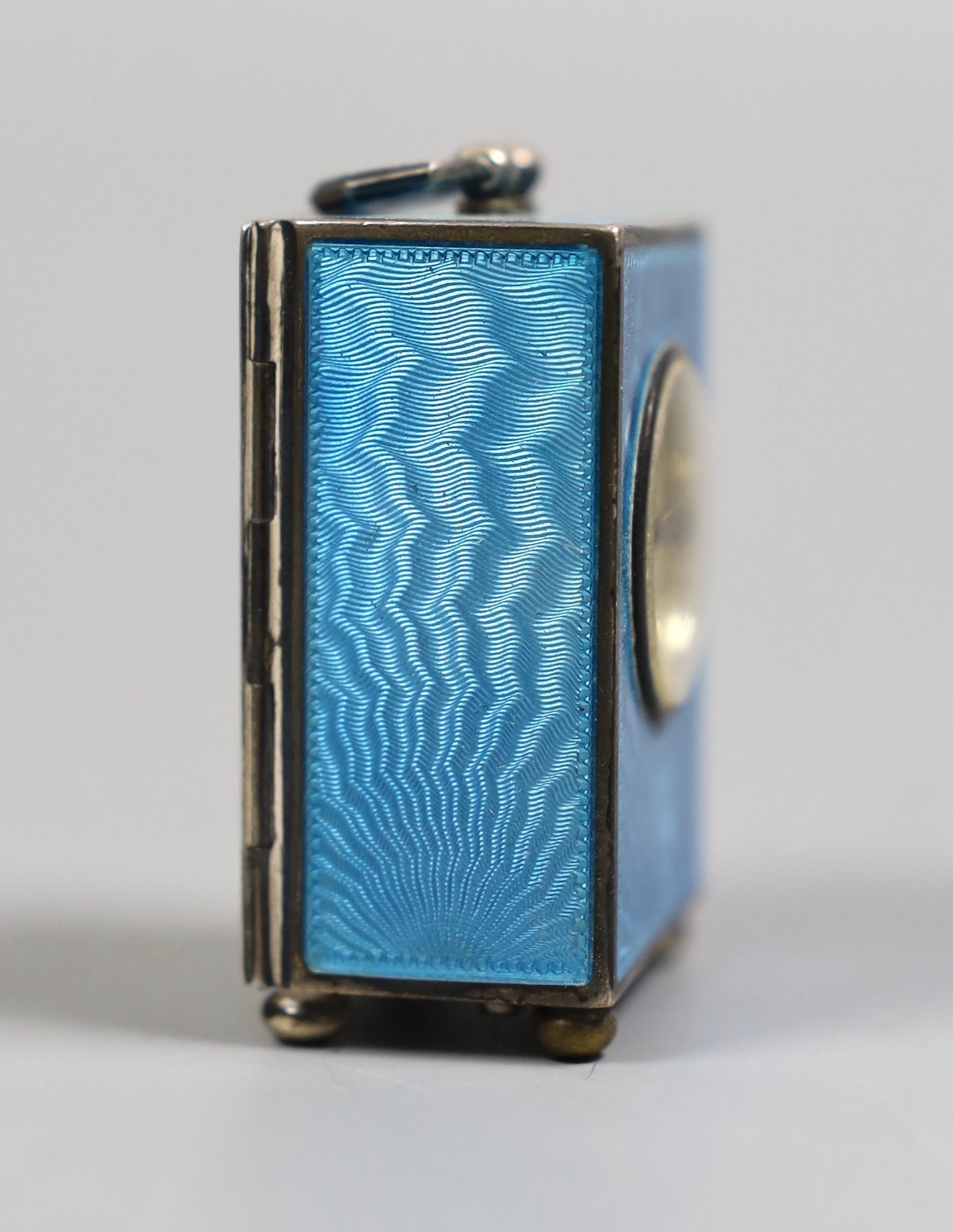 A George V Swiss blue enamel and silver cased miniature carriage timepiece, import marks for Arthur George Rendell, London, 1924, 43mm, on bun feet, in gilt tooled leather carrying case